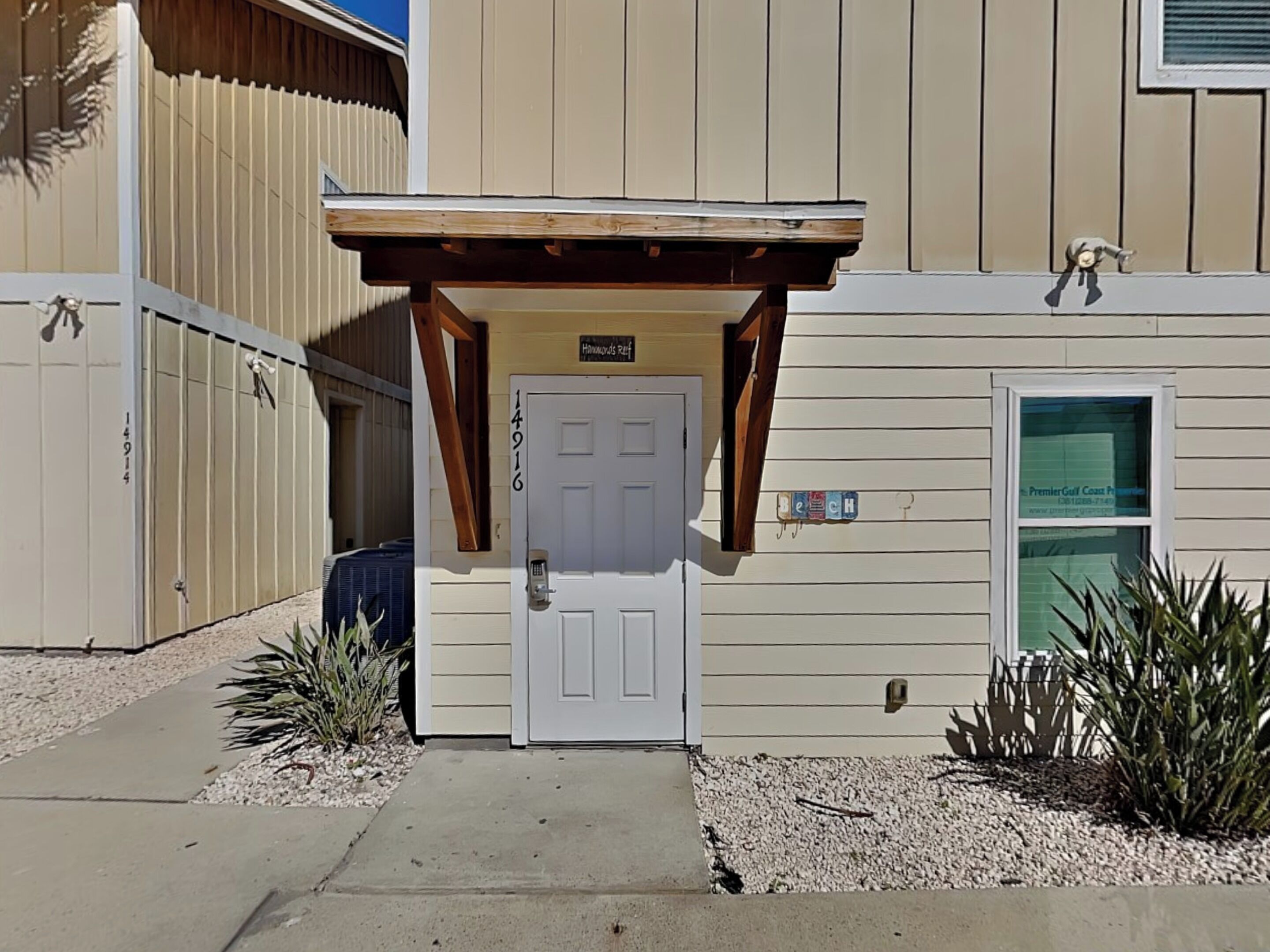 Un bâtiment doté d’un porche en bois, d’une porte blanche et d’une enseigne indiquant « Hammond’s Ref ».