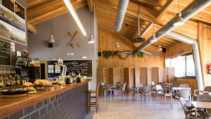 A restaurant with a brick counter, wooden ceiling, and a seating area with tables and chairs. - Bungalow For 4, Terrace - Zumaia, Spain (Zumaya)