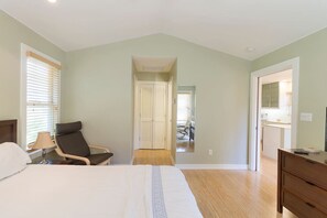A bedroom with a bed, a chair, a dresser, and a mirror. - Sojourn on Cherry Lane (Austin)