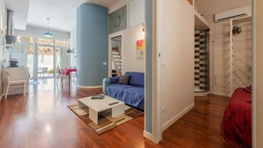 Ein modernes Wohnzimmer mit Essbereich, einer Couch, einem Couchtisch und einer Treppe zu einer oberen Ebene.