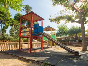 Un parque infantil con tobogán y estructuras para escalar.