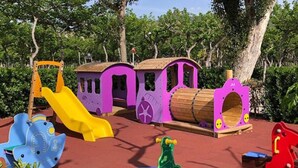 A colorful children's play area with various play structures including a slide, a train, and a caterpillar ride. - 52m² Chalet with Terrace in Benicàssim for 4 people (Benicasim)