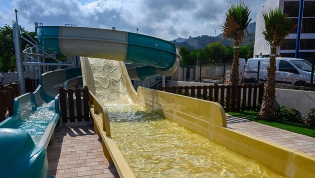 A water slide with a clear water channel, a brick pathway, and a wooden fence. - 52m² Chalet with Terrace in Benicàssim for 4 people (Benicasim)