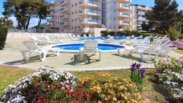 A modern building with a pool and sun loungers. - Vancouver Relax: Air-Conditioned Apartment with Pool, Parking, and 7-Min Walk to Cala Fon Beach (Salou)