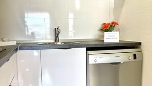Una cocina con lavavajillas Bosch, un lavabo y un florero con flores en la encimera.