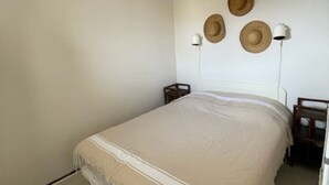 A bedroom with a bed, two bedside tables, and three wall-mounted lamps. - Charming Apartment in Saint Pierre La Mer with Pool and Parking (Fleury-Saint-Pierre-la-Mer)