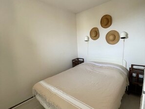 Ein Schlafzimmer mit einem Bett, zwei Nachttischen und drei Wandleuchten.