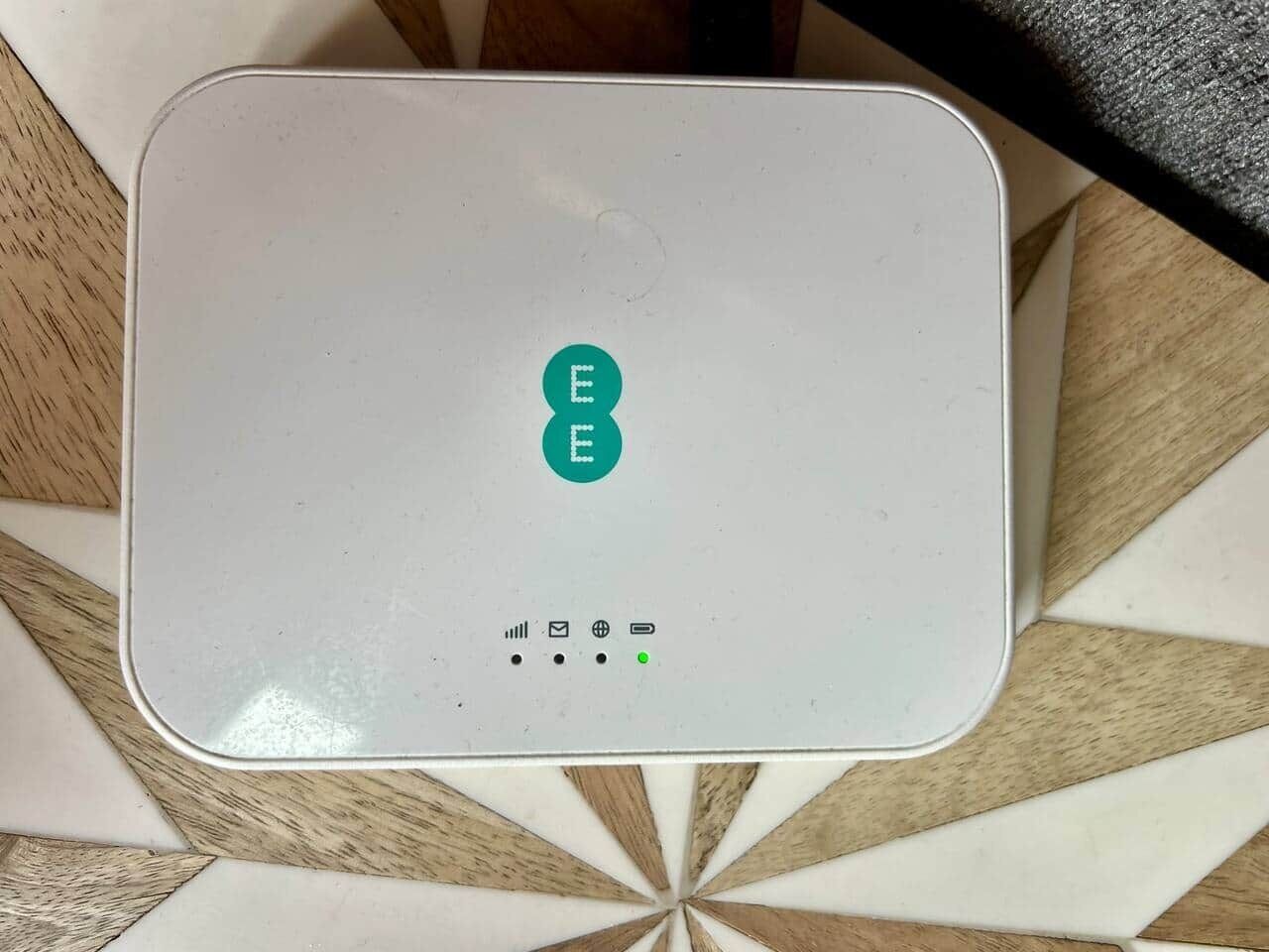 Een wit elektronisch apparaat met een logo en verschillende pictogrammen op het oppervlak.