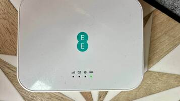 Een wit elektronisch apparaat met een logo en verschillende pictogrammen op het oppervlak.