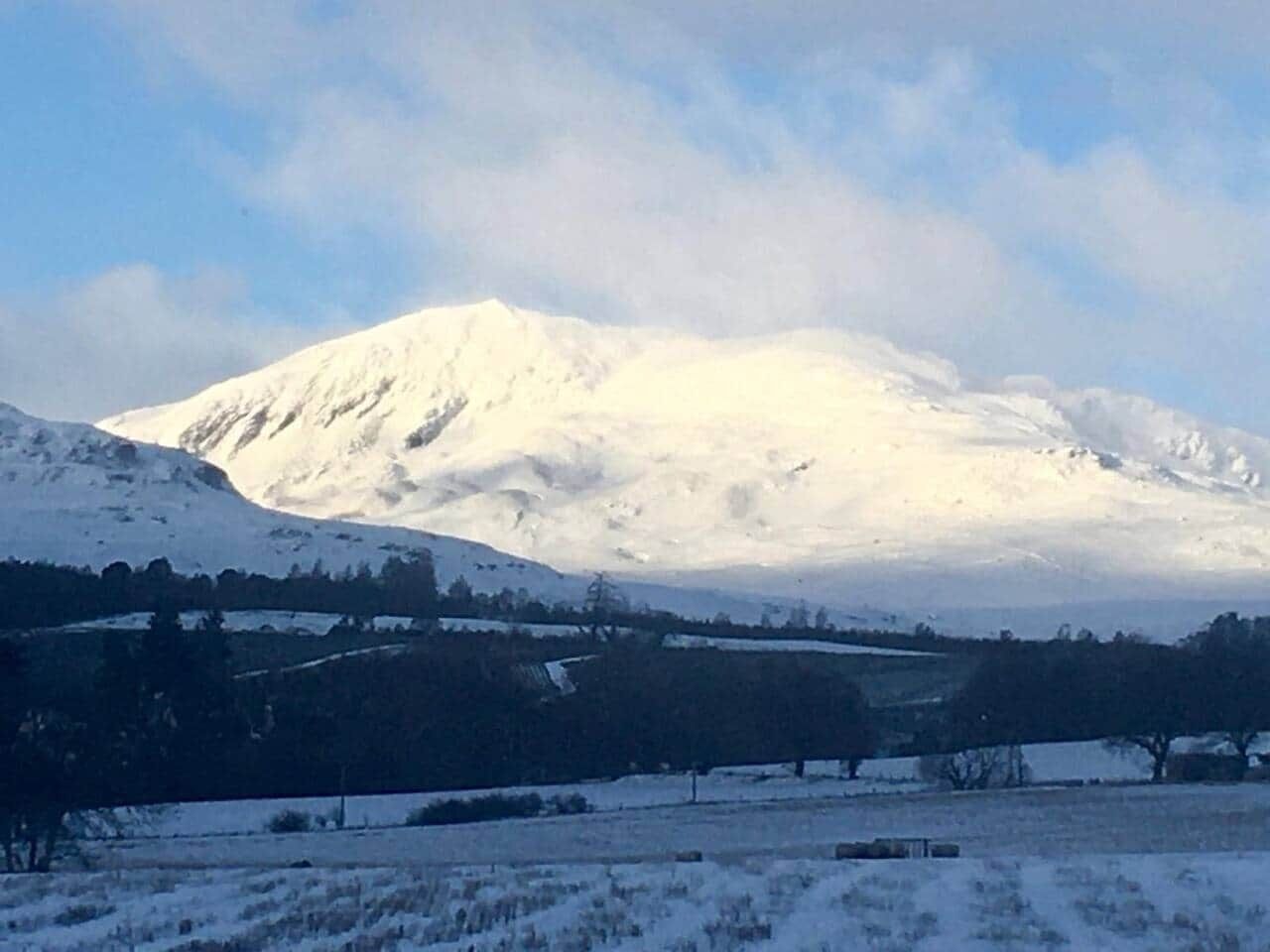 Paisatge de muntanya cobert de neu amb un cel serè.