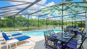 Un espacio exterior cubierto con piscina, sillas de descanso y una mesa de comedor con sillas.