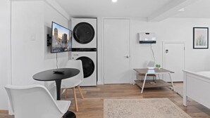 Een modern, goed verlicht appartement met een eetgedeelte, een zithoek en een keuken.