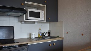 Eine kompakte Küche mit Mikrowelle, Geschirrspüler und Spüle.