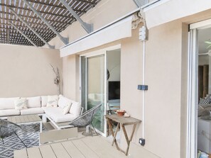 A covered outdoor seating area with a sofa, chairs, and a table. - Elegant Top Floor 2BR, 4****, Air Conditioning, 4 Guests (Sète)