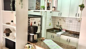 A compact kitchen with white cabinets, a microwave, a coffee maker, and a sink. - Beautiful beachfront apartment with air conditioning, pool, and parking in La Pineda (La Pineda)