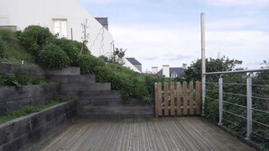 A wooden deck with a metal fence and steps leading up to a white building. - Cozy townhouse, port view, in the heart of Sauzon (Sauzon)