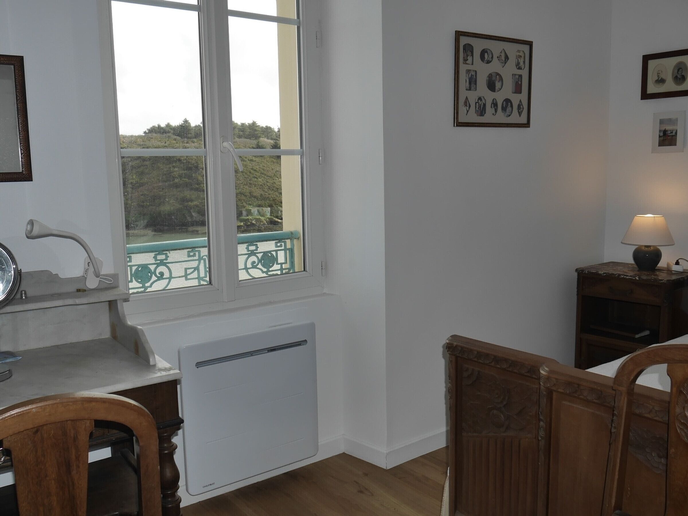 Eine Küche mit Fenster, Heizkörper, Spüle und einem Stuhl.