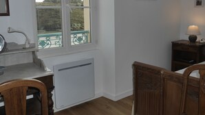 A kitchen with a window, a radiator, a sink, and a chair. - Cozy townhouse, port view, in the heart of Sauzon (Sauzon)