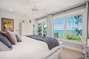Ein Schlafzimmer mit einem großen Bett, einem Deckenventilator und Blick auf den Ozean.