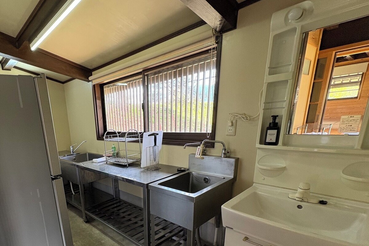 Una cocina compacta con refrigerador, lavamanos y ventana.