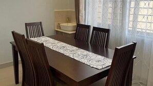 A dining area with a long wooden table, six chairs, and a patterned table runner. - Large spacious family friendly 4 bedroom home in Lilongwe (Lilongwe)