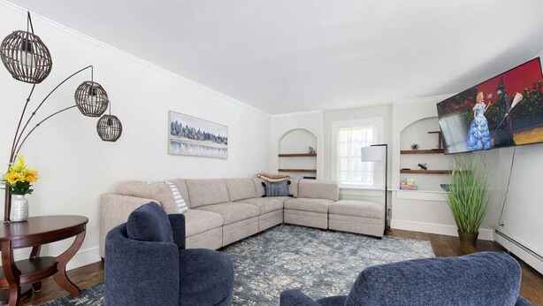 A modern living room with a sectional sofa, a round coffee table, and a floor lamp. - Enclosed Hot Tub, King Bed, 3 bdrm, close to town (Ellenville)