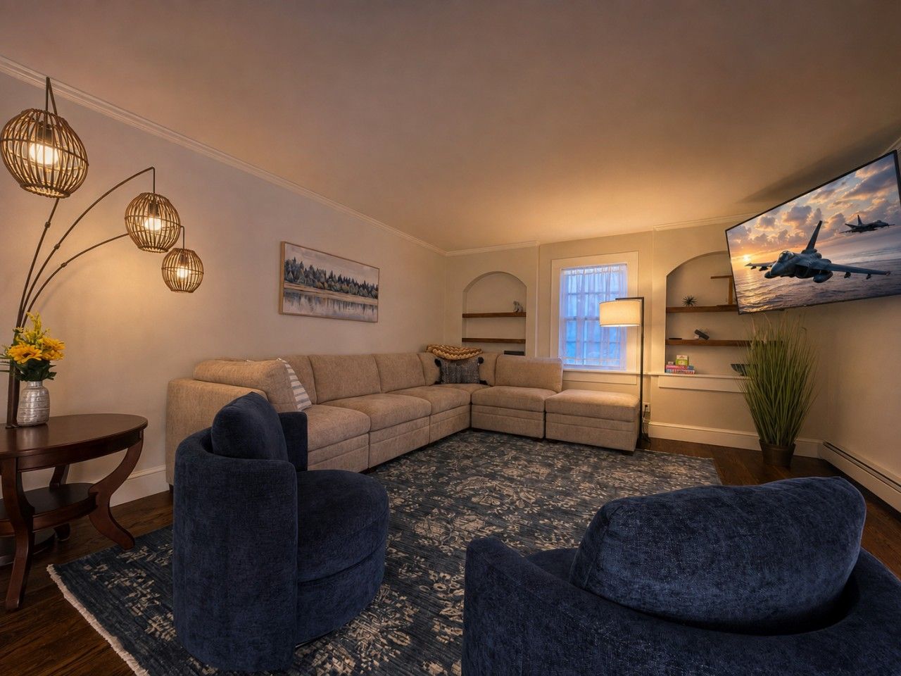A living room with a sectional sofa, two armchairs, a round coffee table, and a floor lamp.