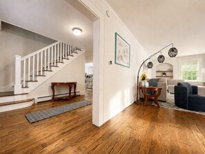 Un vaste espace de vie doté d’un plancher en bois franc, d’un escalier et d’un coin repas.