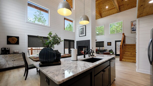 A spacious kitchen with a large island, wooden beams, and a fireplace. - Pancakes & Sausage | Hot Tub • Slide • Game Loft (Broken Bow)