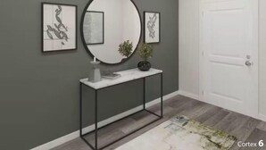 A hallway with a white door, a console table with a mirror, and two framed artworks on the wall. - Masters Week Retreat (Grovetown)