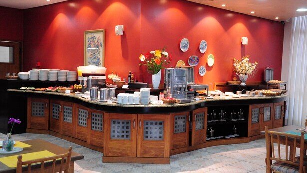 A breakfast bar with a variety of food items and a coffee machine. - park hotel morotin (Santa Maria)