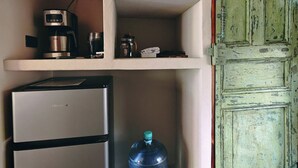 Et tekøkken med køleskab, kaffemaskine og vanddispenser.