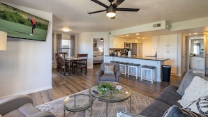 A modern living room with a dining area, kitchen, and a ceiling fan. - Stonecreek Golf Condo | Heated Pool & Spa (Scottsdale)
