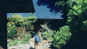 A pathway leading to a traditional building surrounded by greenery. - Kominka Yado Loof Sawanoie (Fuefuki)