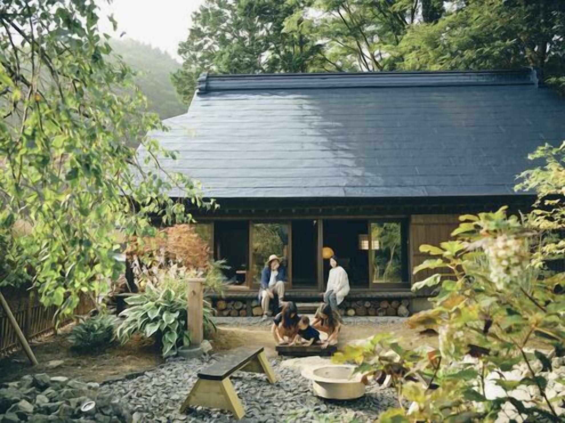 Uma casa tradicional japonesa com telhado escuro e varanda de madeira.