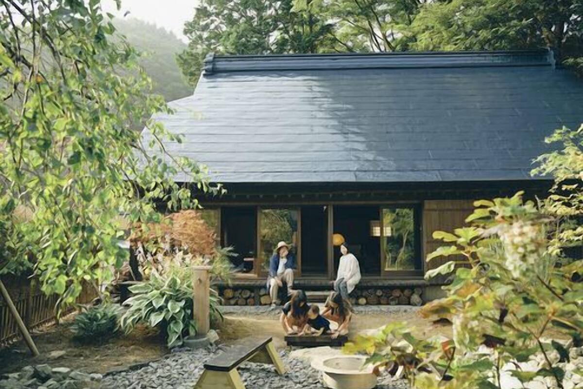 A traditional Japanese-style house with a dark roof and a wooden porch.