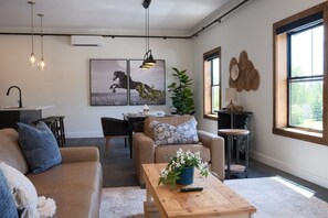 Un salon moderne avec un canapé, une table basse et un coin repas.