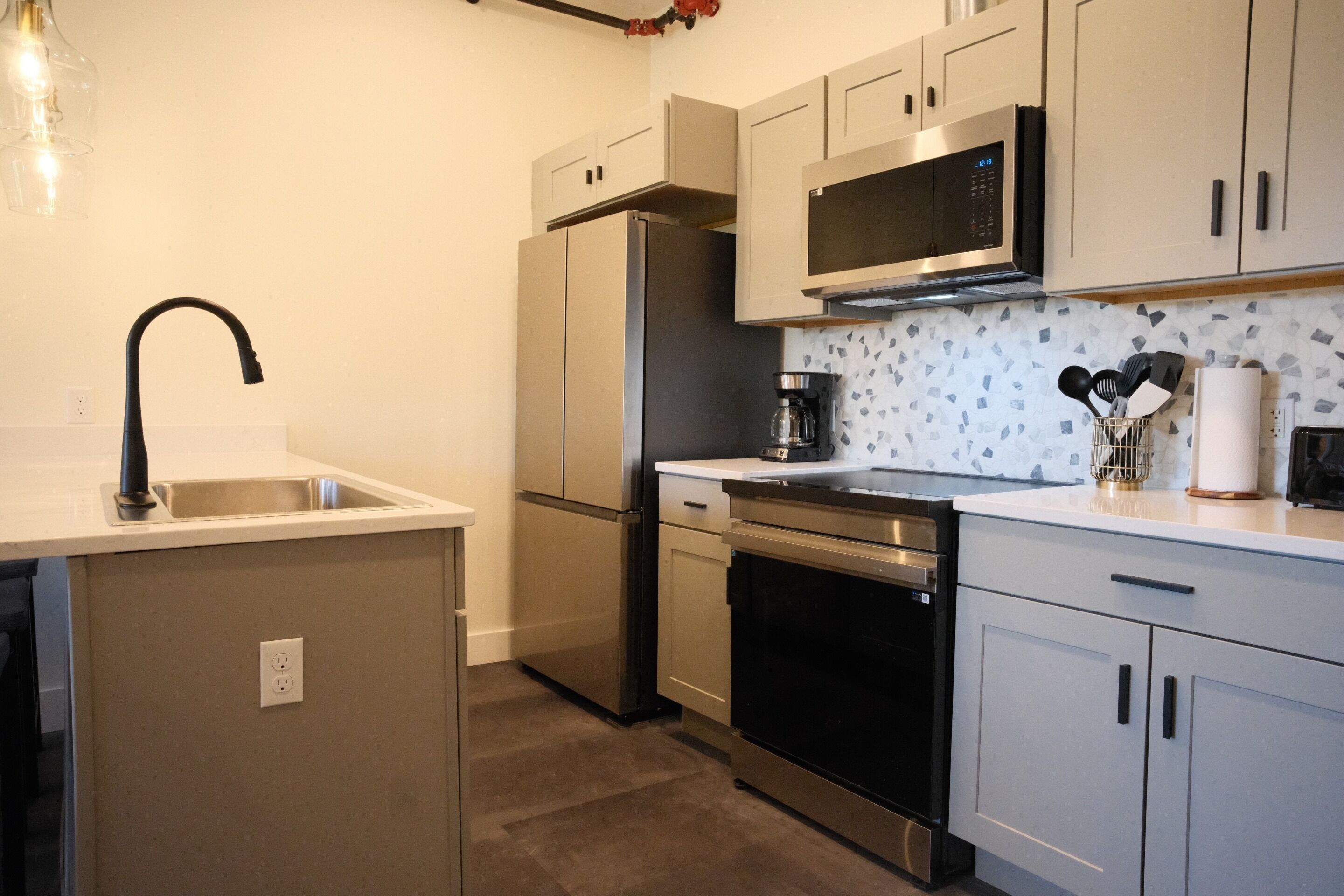 A modern kitchen with stainless steel appliances, a microwave, and a coffee maker.