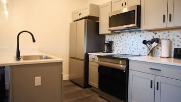 A modern kitchen with stainless steel appliances, a microwave, and a coffee maker.