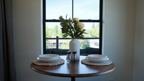Een eettafel met twee witte borden, een bloevas en zout- en peperstel.