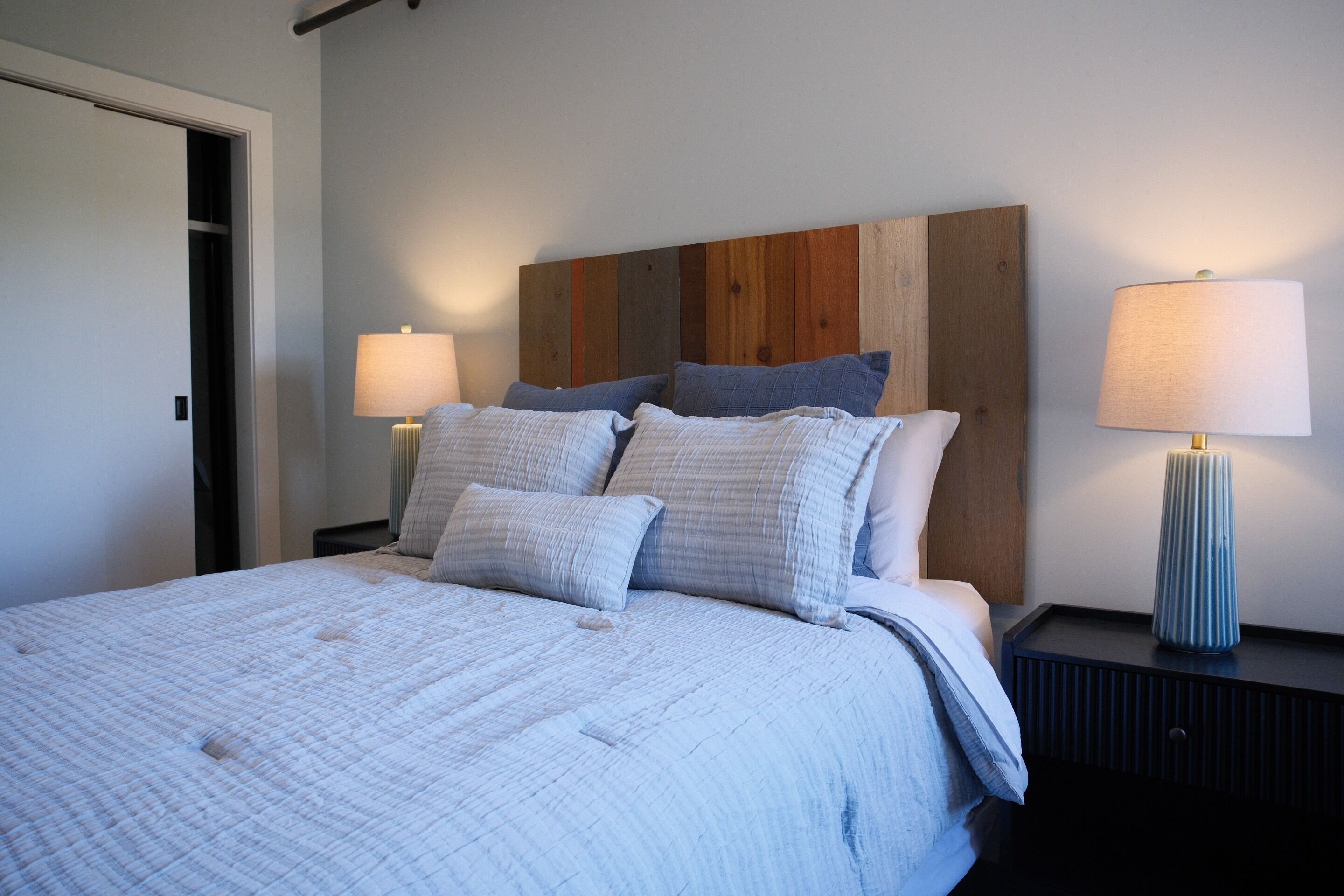 A bedroom with a bed, two bedside tables, and a nightstand.