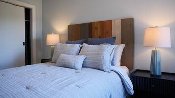 A bedroom with a bed, two bedside tables, and a nightstand.