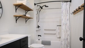 Un baño con inodoro, ducha, bañera y lavamanos.