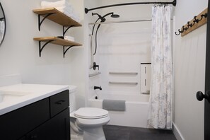 A bathroom with a toilet, a shower, a bathtub, and a sink.