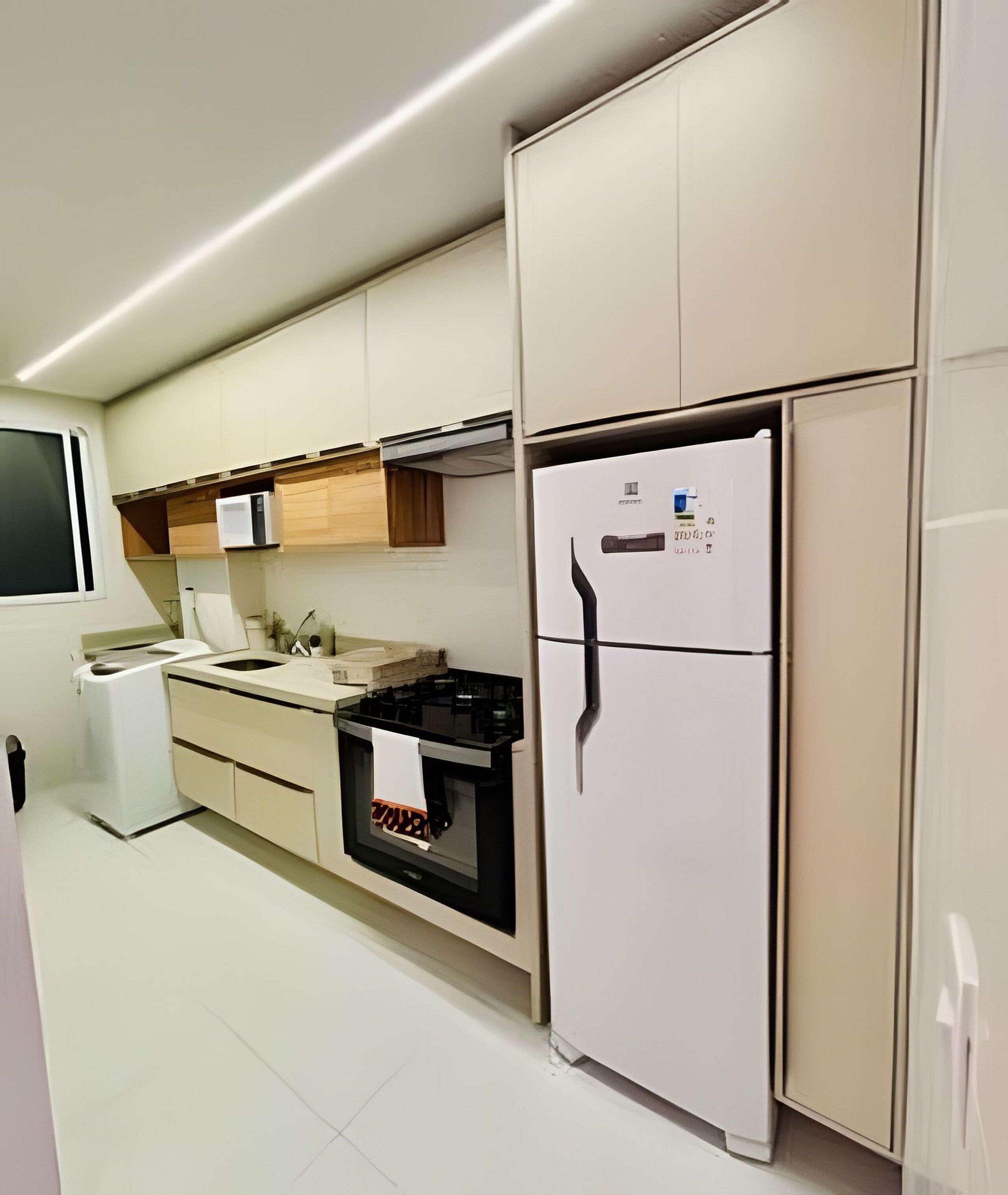 A modern kitchen with a built-in oven, microwave, and a refrigerator.