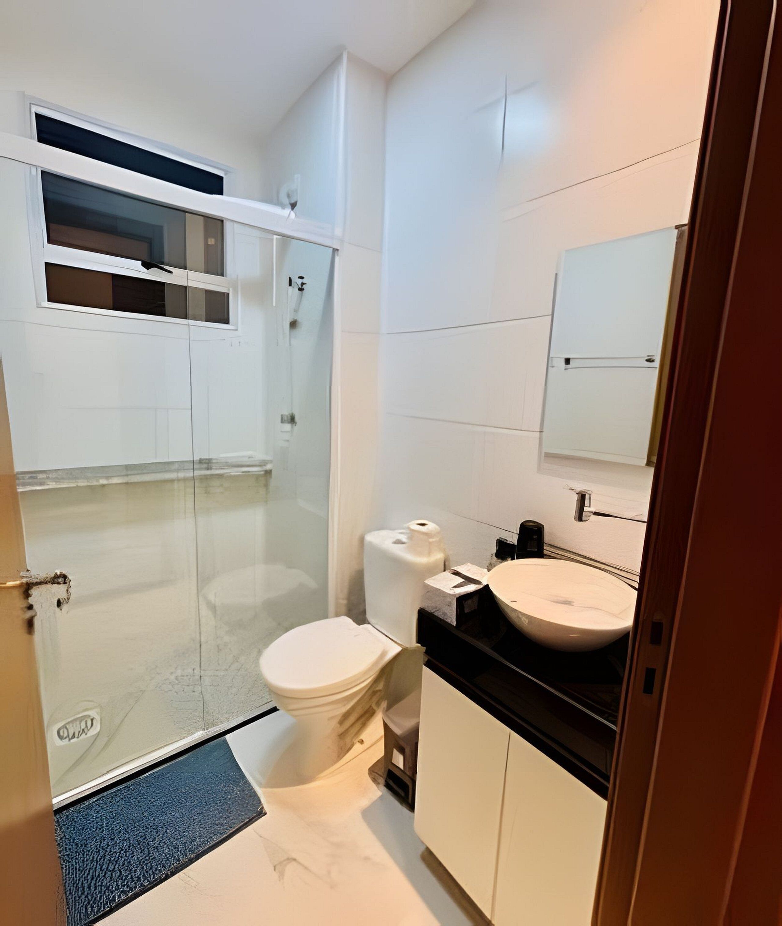A modern bathroom with a toilet, sink, and shower.