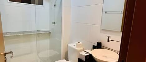 A modern bathroom with a toilet, sink, and shower.