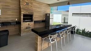 Una cocina moderna con una isla central, luces colgantes y una pared de ladrillo decorativa.