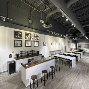 Una cocina moderna con una isla central, taburetes de bar e iluminación colgante.