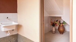 A bathroom with a white sink, a tiled floor, and two vases with flowers. - Apartment in downtown Búzios | 2 bedrooms | Air conditioning (Armação dos Búzios)